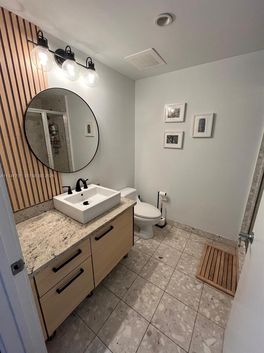 185 Southwest 7th Street, Unit 2006 Miami, FL 33130 - Photo 7 of 14 a bathroom with a granite countertop sink and mirror