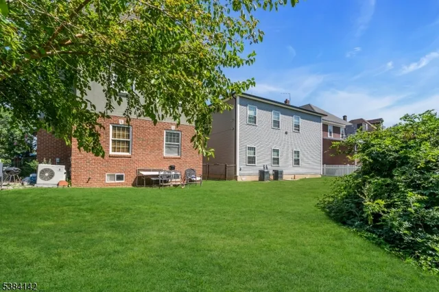 a view of a backyard with plants and large tree