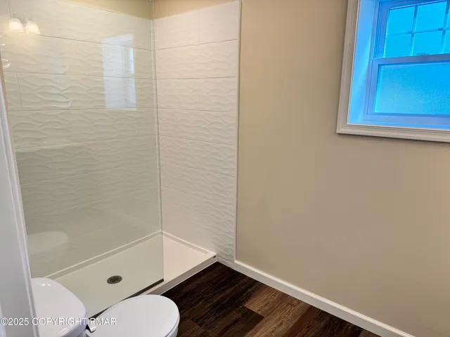 a bathroom with a toilet and a shower