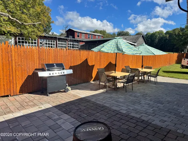 a view of a patio with a table and chairs under an umbrella