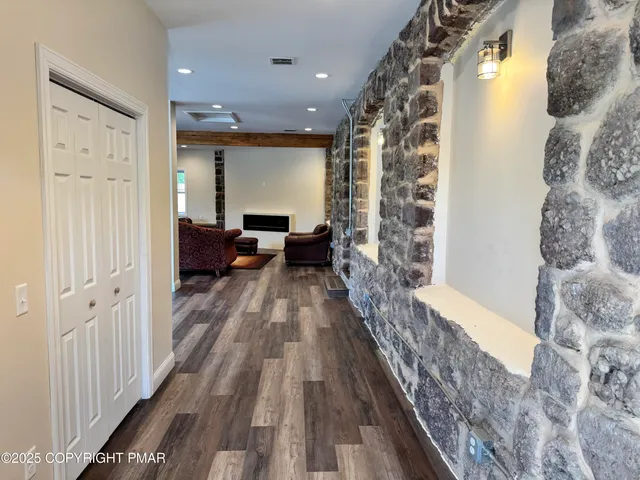 a view of a hallway with wooden floor and furniture