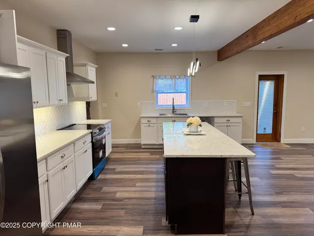 a open kitchen with kitchen island a sink dishwasher stove with wooden cabinets and floor