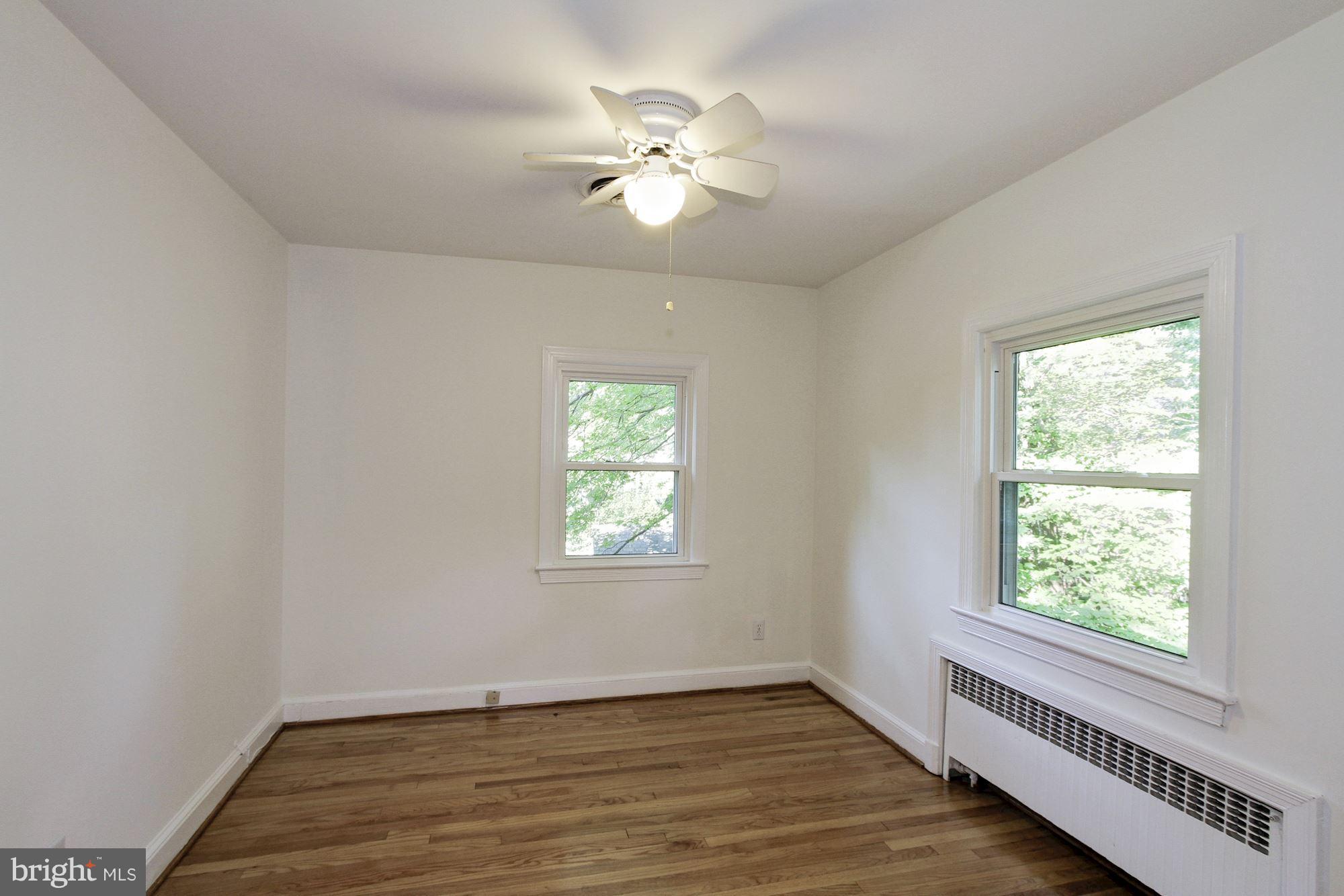 102 Wayne Avenue Silver Spring, MD 20901 - Photo 19 of 29 a view of an empty room with wooden floor and a window