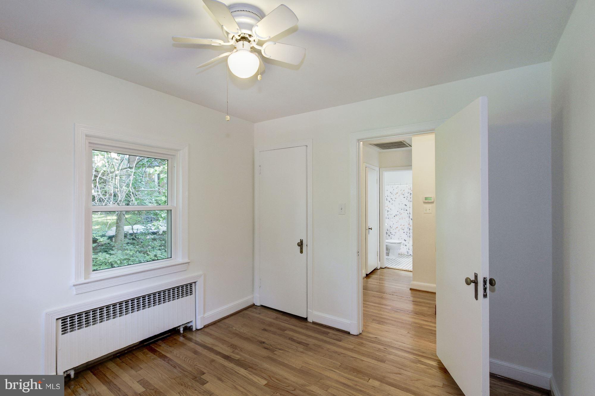 102 Wayne Avenue Silver Spring, MD 20901 - Photo 20 of 29 a view of an empty room with wooden floor and a window