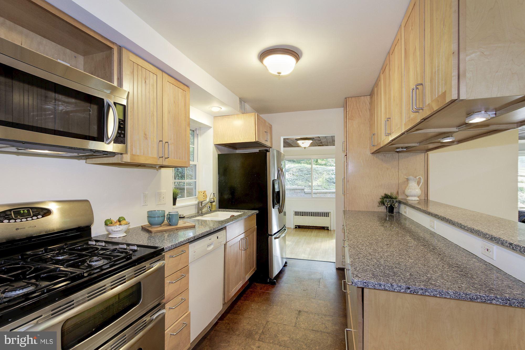 102 Wayne Avenue Silver Spring, MD 20901 - Photo 3 of 29 a kitchen with stainless steel appliances granite countertop a stove and a microwave