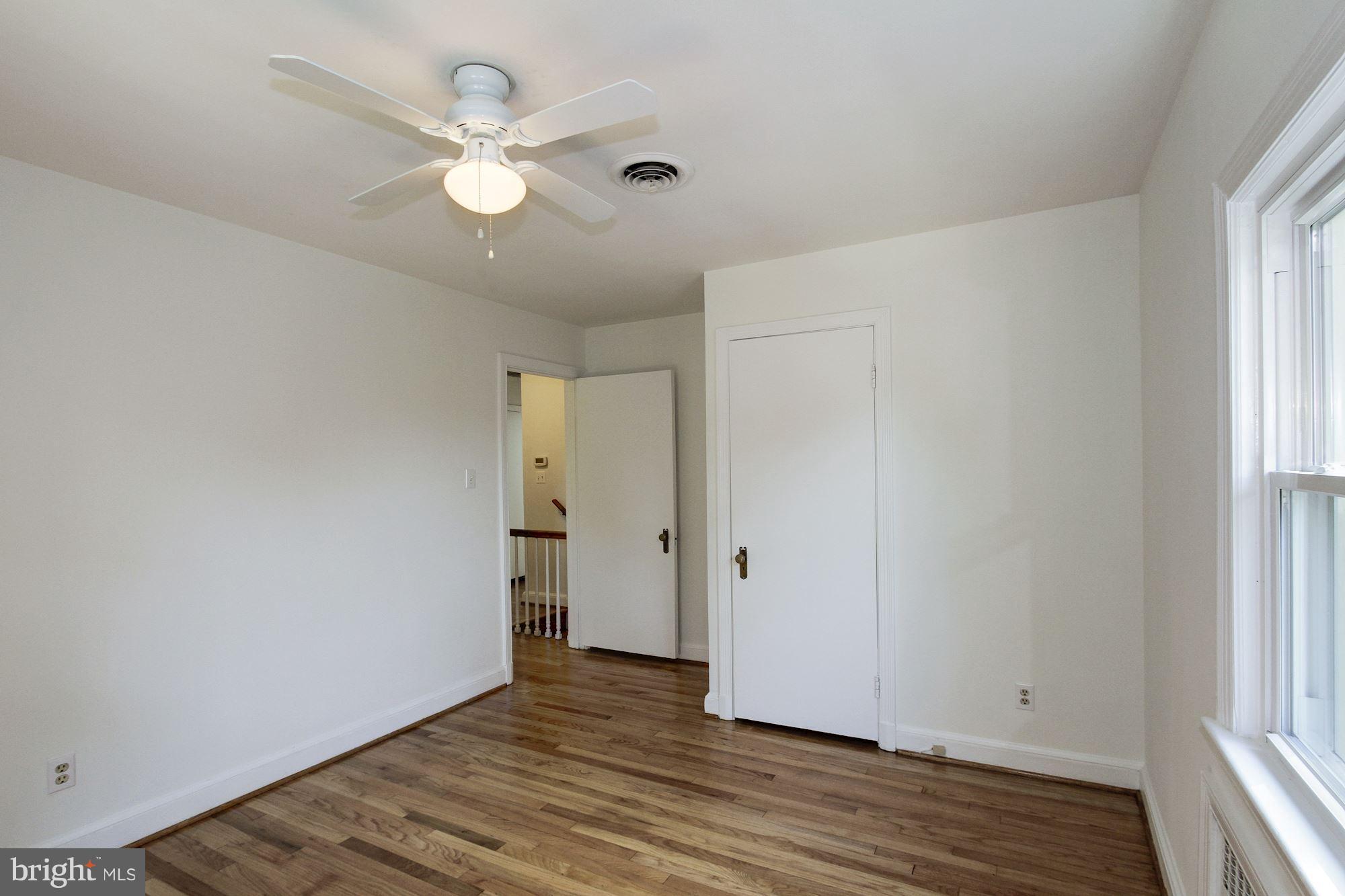 102 Wayne Avenue Silver Spring, MD 20901 - Photo 23 of 29 an empty room with wooden floor and ceiling fan