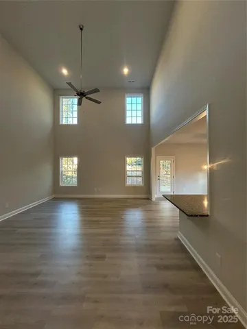 a view of an empty room with window and wooden floor