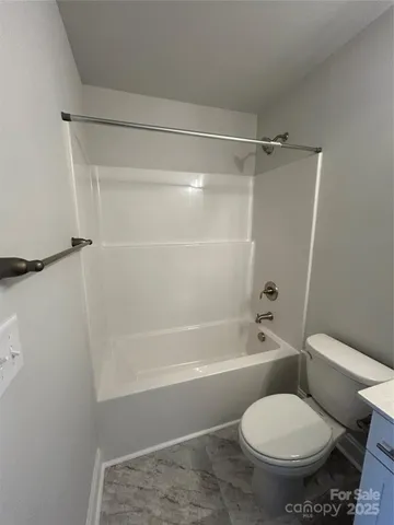 a white toilet sitting next to a bath tub and a shower