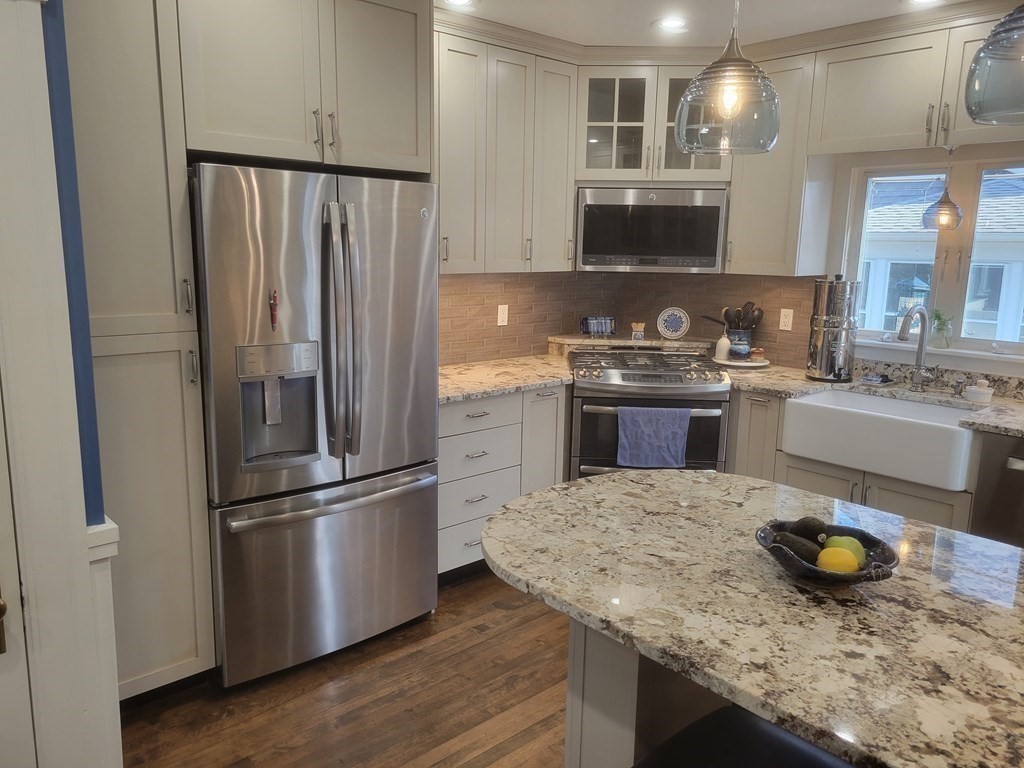 970 Pleasant Street Worcester, MA 01602 - Photo 13 of 39 a kitchen with stainless steel appliances granite countertop a sink stove and refrigerator