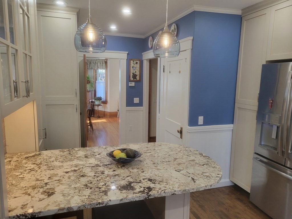 970 Pleasant Street Worcester, MA 01602 - Photo 15 of 39 a bathroom with a granite countertop sink a refrigerator and a mirror