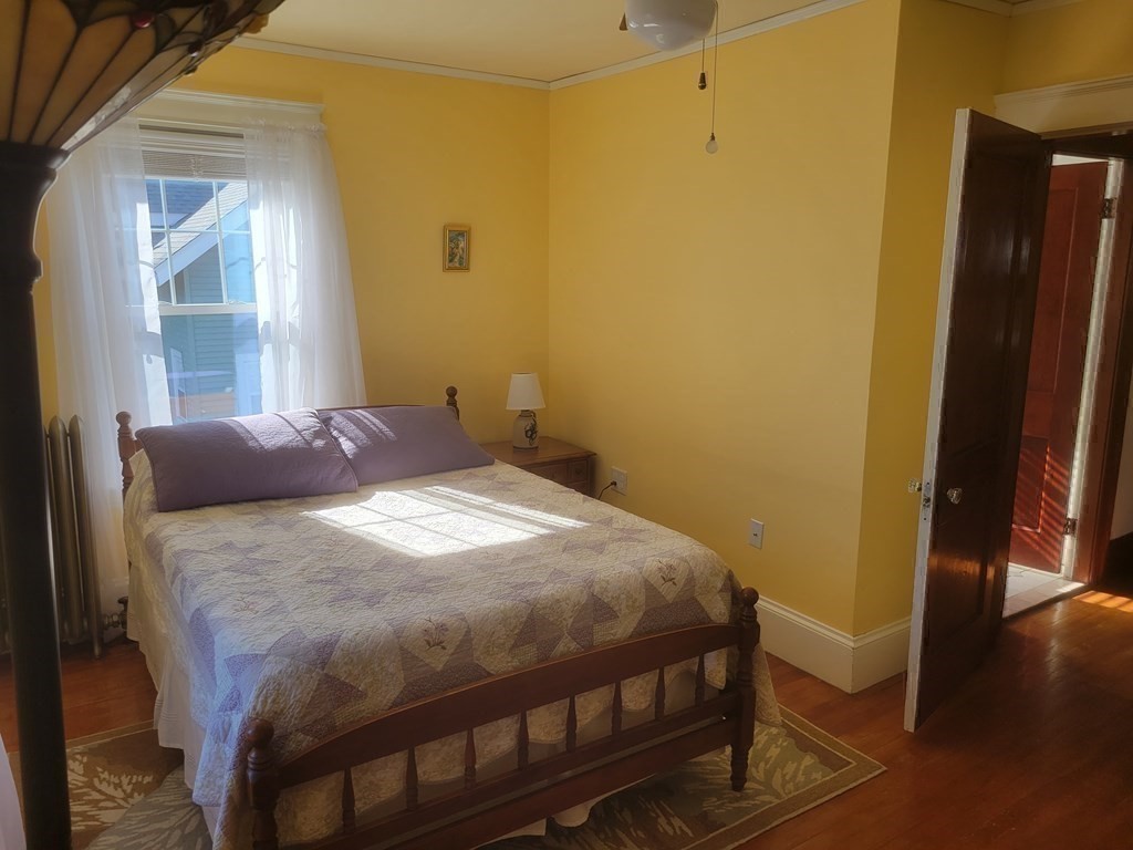 970 Pleasant Street Worcester, MA 01602 - Photo 35 of 39 a bedroom with a bed and wooden floor
