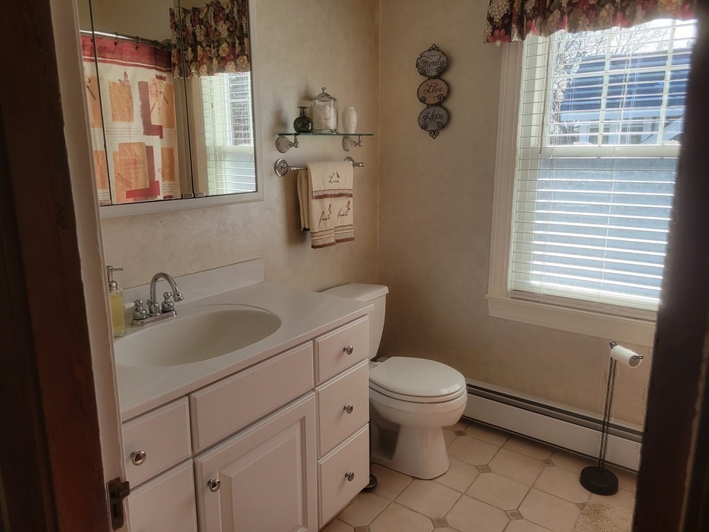 970 Pleasant Street Worcester, MA 01602 - Photo 38 of 39 a bathroom with a granite countertop sink toilet and mirror