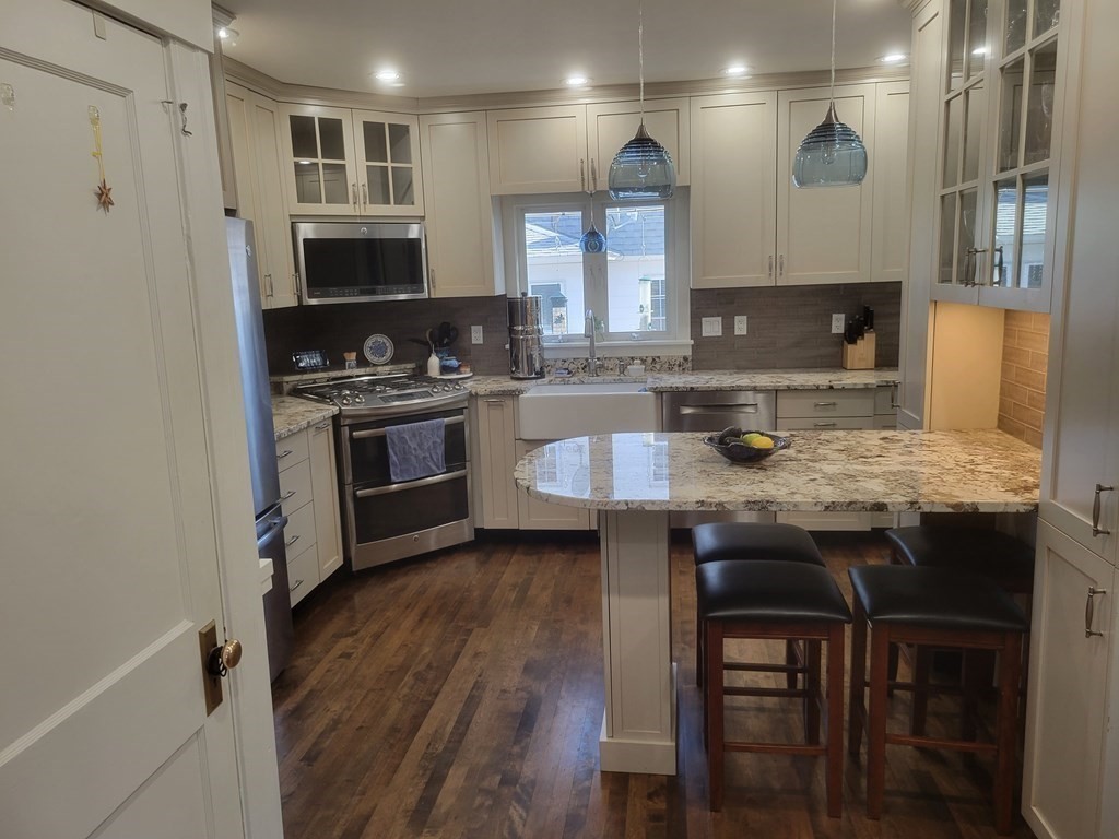 970 Pleasant Street Worcester, MA 01602 - Photo 8 of 39 a kitchen with granite countertop a stove a sink and wooden floor