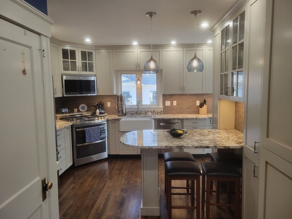 970 Pleasant Street Worcester, MA 01602 - Photo 9 of 39 a kitchen with kitchen island granite countertop a sink cabinets and stainless steel appliances