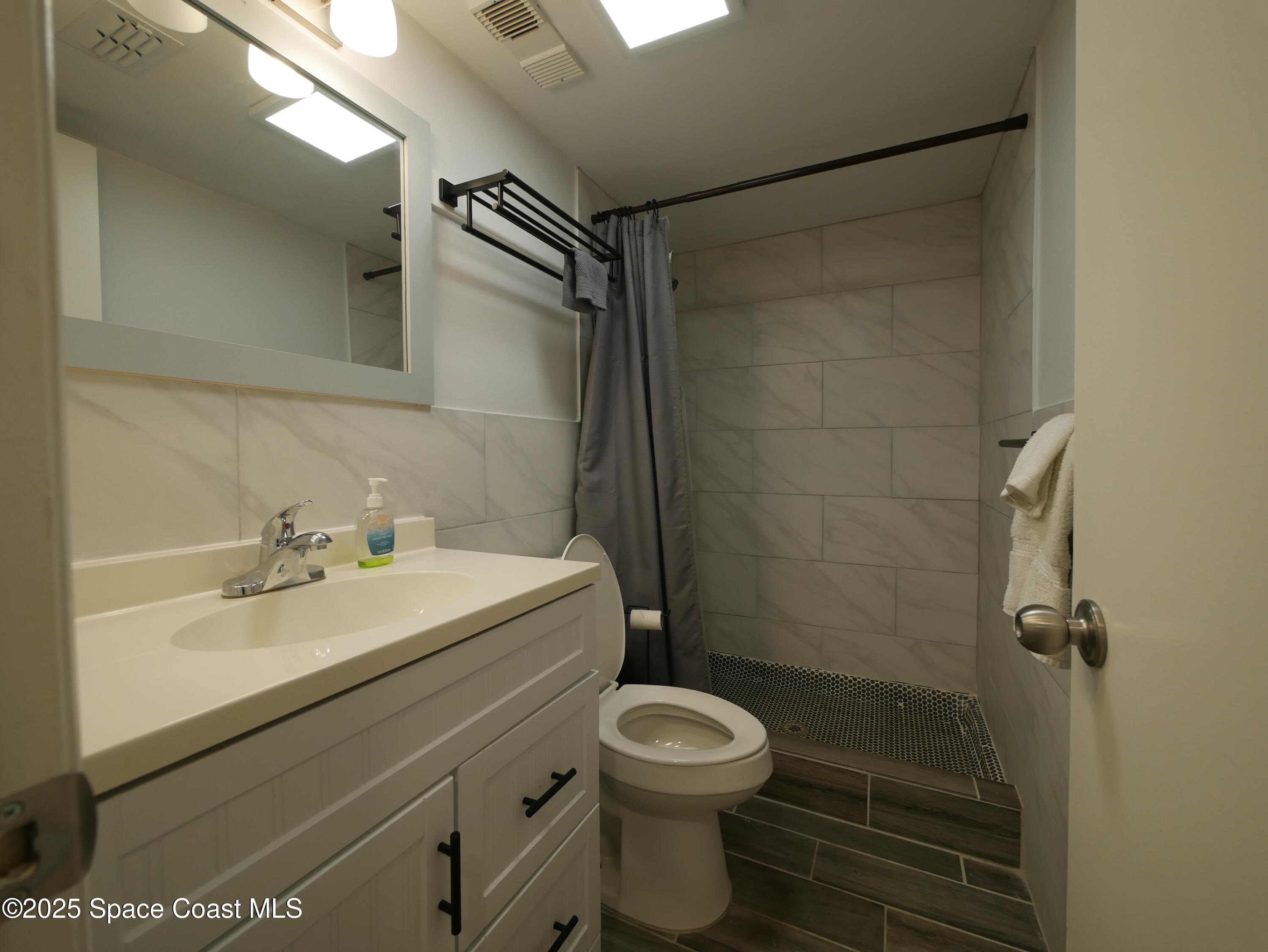 1318 South Miramar Avenue, Unit 208 Indialantic, FL 32903 - Photo 12 of 20 a bathroom with a sink a toilet and shower