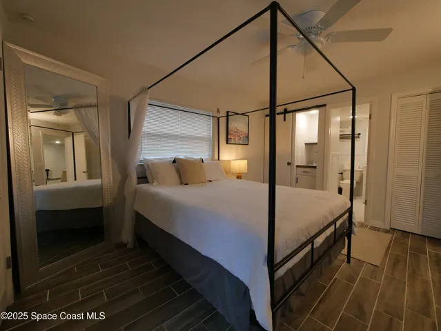 a bedroom with a bed and wooden floor