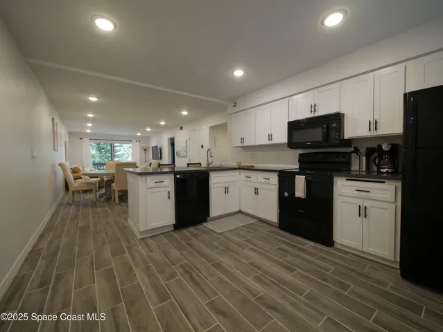 a kitchen with stainless steel appliances kitchen island granite countertop a sink counter space cabinets and a counter top space