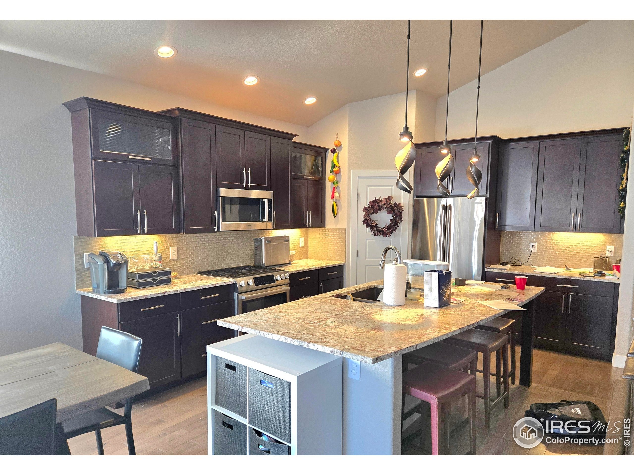 7292 McClellan Road Wellington, CO 80549 - Photo 15 of 19 a kitchen with kitchen island granite countertop a sink appliances and cabinets