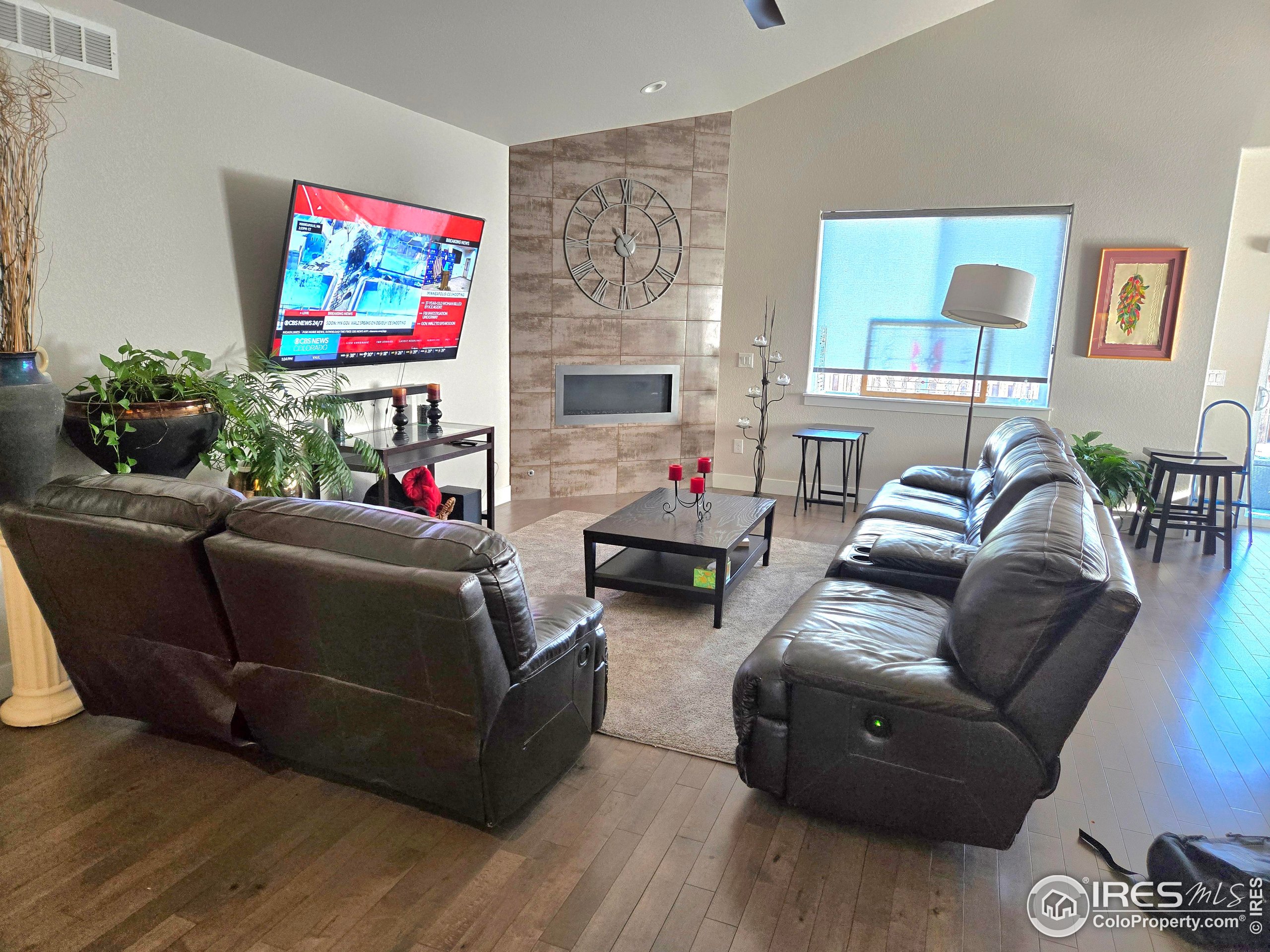 7292 McClellan Road Wellington, CO 80549 - Photo 19 of 19 a living room with furniture a flat screen tv and a wall painting