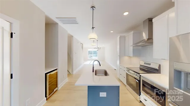 a kitchen with kitchen island a stove a sink and a refrigerator with wooden floor