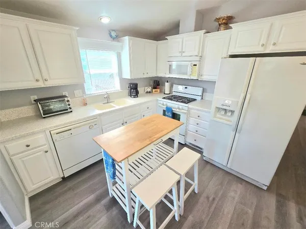 a kitchen with white cabinets and white appliances