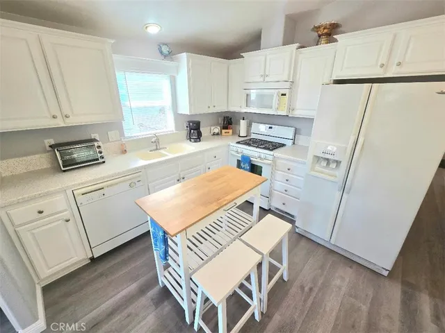 a kitchen with white cabinets and white appliances
