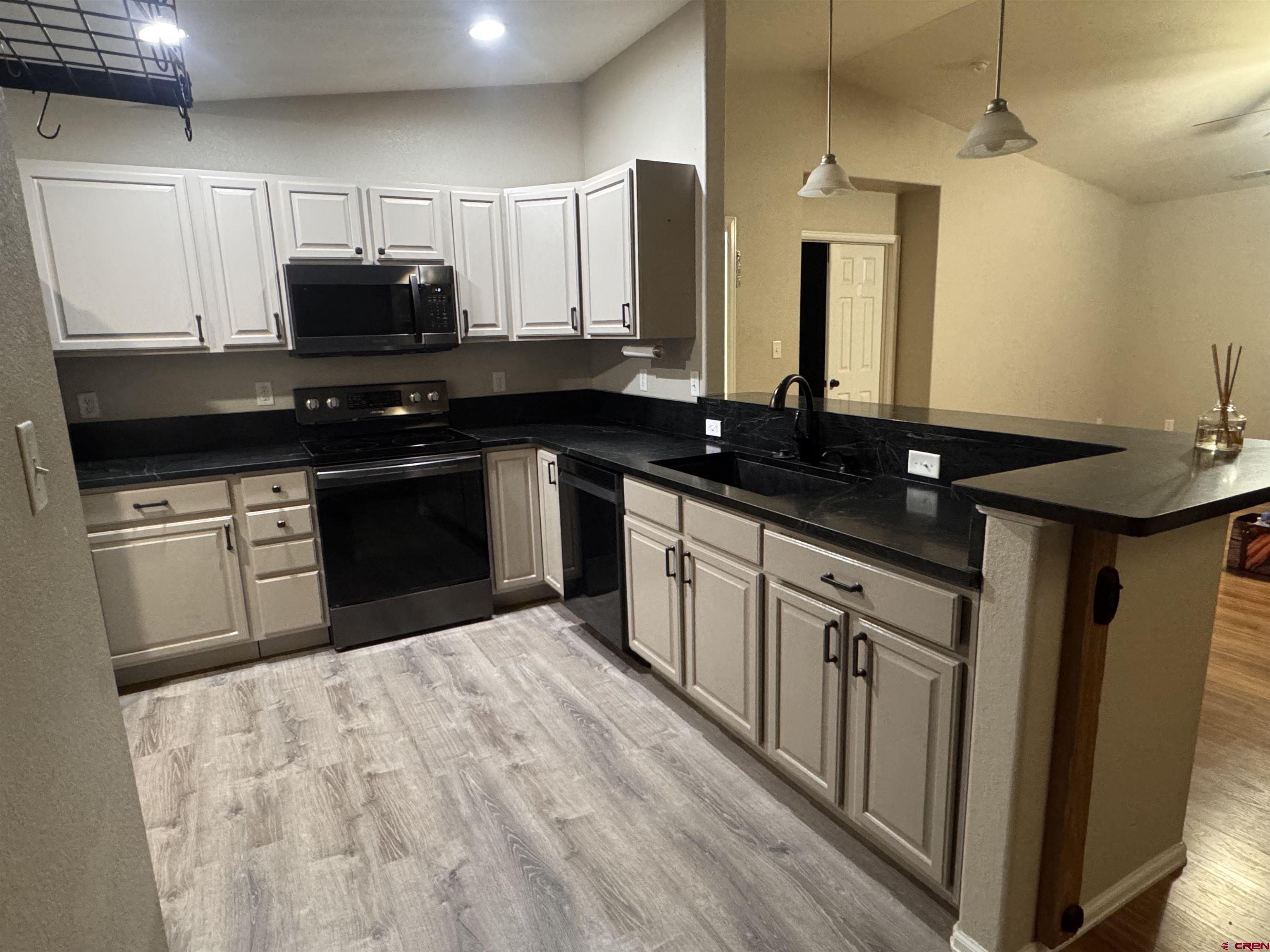 1984 Sapphire Way Delta, CO 81416 - Photo 14 of 22 a kitchen with stainless steel appliances granite countertop a sink stove and microwave