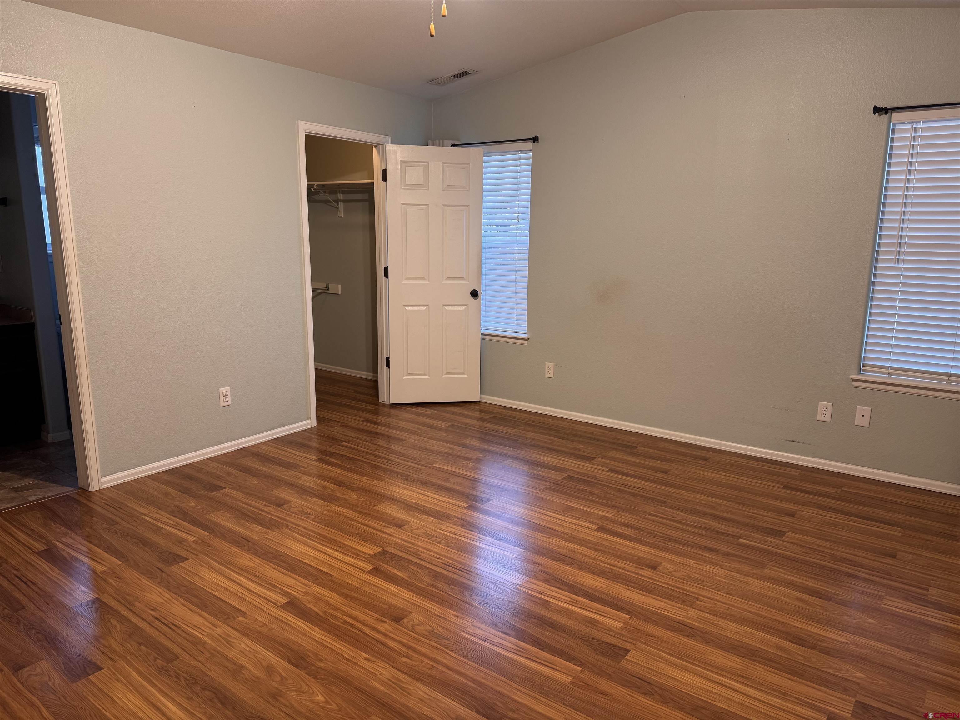 1984 Sapphire Way Delta, CO 81416 - Photo 17 of 22 an empty room with wooden floor and windows