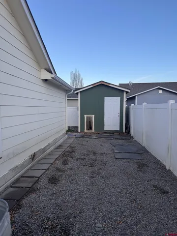 a view of a backyard with chairs and a grill