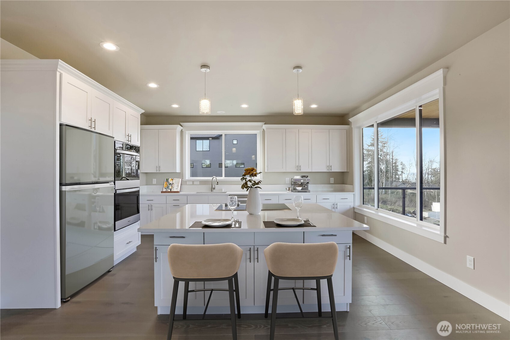 3706 West 3rd Street Anacortes, WA 98221 - Photo 11 of 40 a kitchen with a dining table chairs refrigerator and cabinets