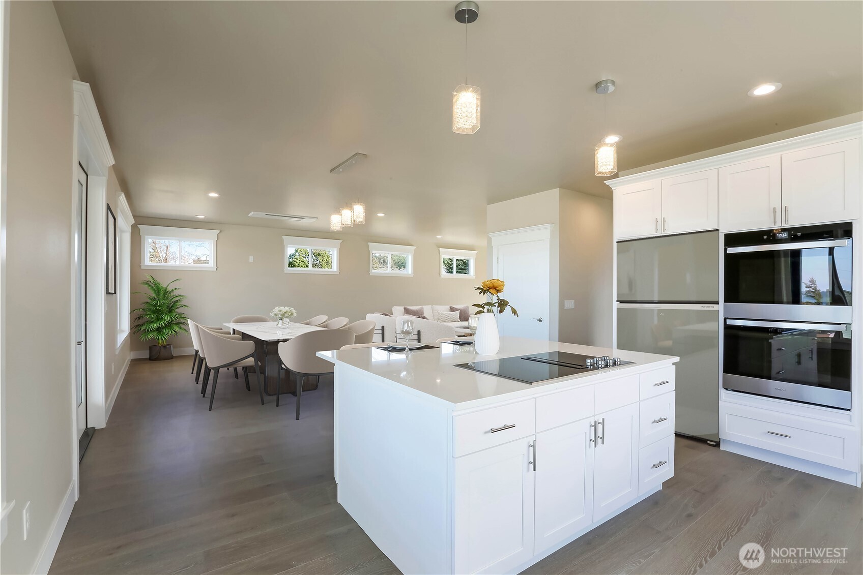 3706 West 3rd Street Anacortes, WA 98221 - Photo 13 of 40 a kitchen with a sink dishwasher a stove and white cabinets with wooden floor