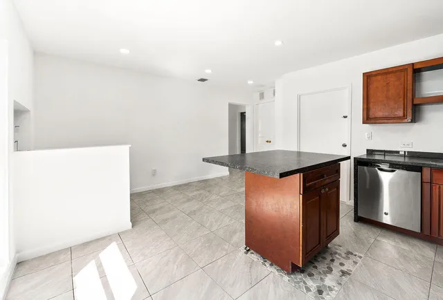 a kitchen with stainless steel appliances granite countertop a sink a stove and a refrigerator