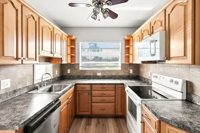 a kitchen with a stove a sink and a granite counter tops