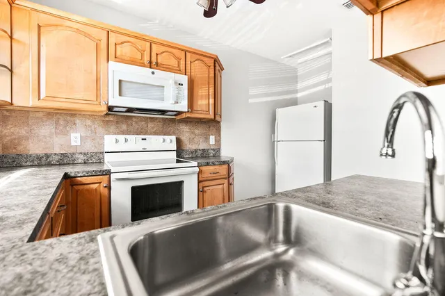 a kitchen with stainless steel appliances granite countertop a sink and a stove