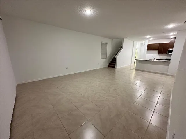 a view of a livingroom with an empty space and a refrigerator