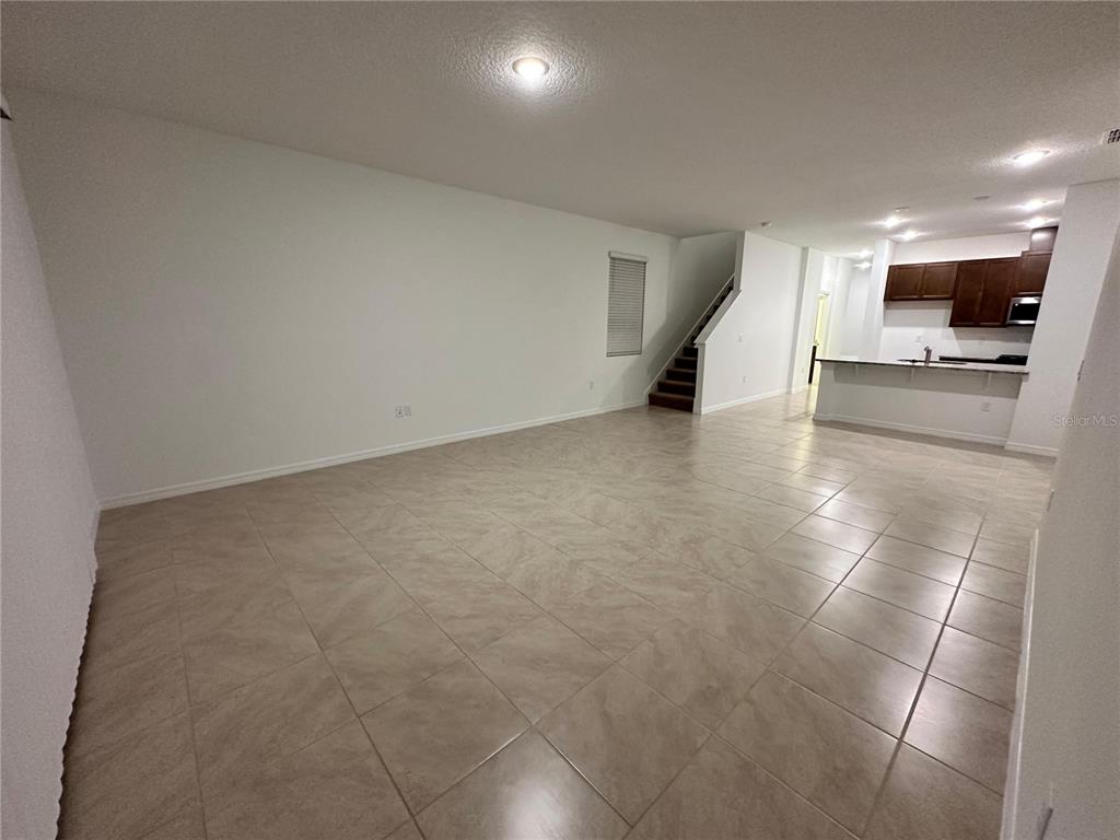 7004 Broad Wing Loop Howey-in-the-Hills, FL 34737 - Photo 4 of 10 a view of a livingroom with an empty space and a refrigerator
