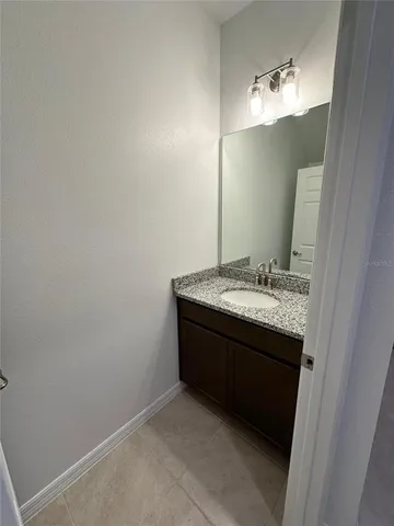 a bathroom with a granite countertop sink a large mirror and a shower