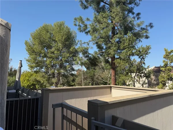 a view of balcony with wooden floor and fence