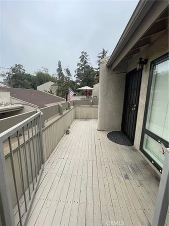 a view of a balcony with wooden floor and fence