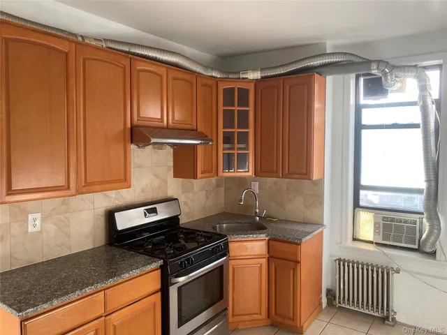 a kitchen with granite countertop wooden cabinets and a stove top oven