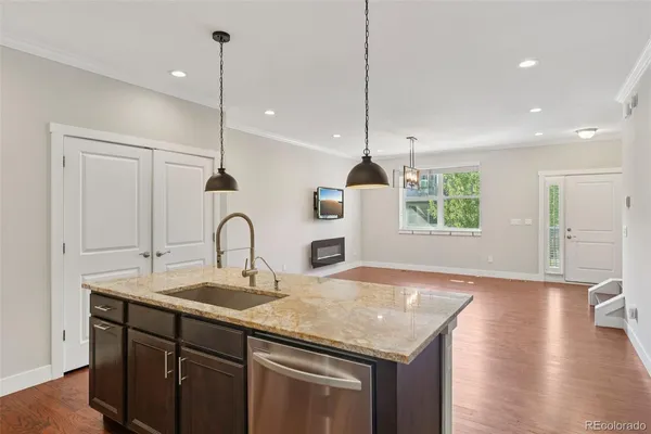 a kitchen with a sink a window and wooden floor