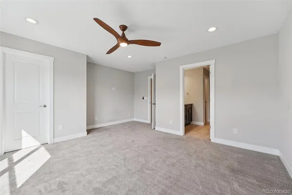 an empty room with closet and windows
