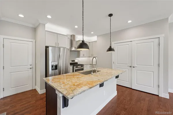 a room with kitchen island a wooden floor stainless steel appliances and wooden floor