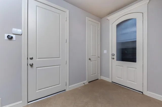 a view of an empty room with closet and a bathroom