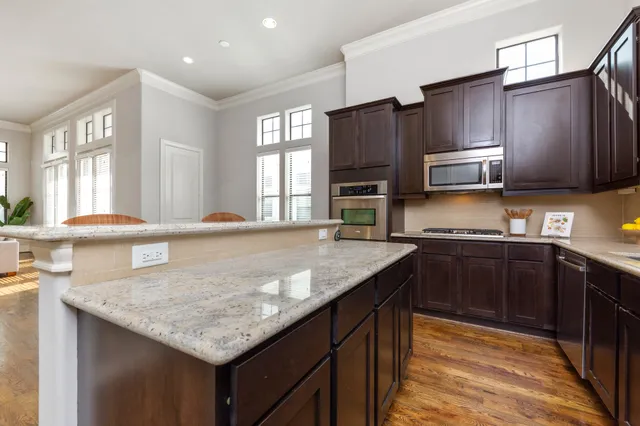 a kitchen with stainless steel appliances granite countertop a sink a stove and a microwave