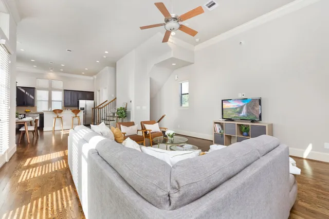 a living room with furniture and a wooden floor