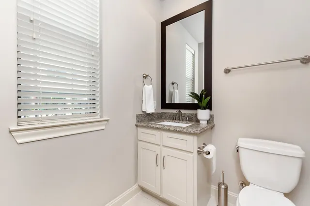 a bathroom with a granite countertop toilet sink and mirror