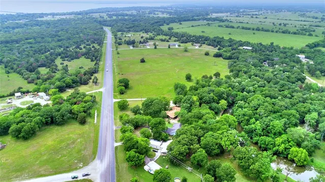 an aerial view of a houses with a yard and lake view