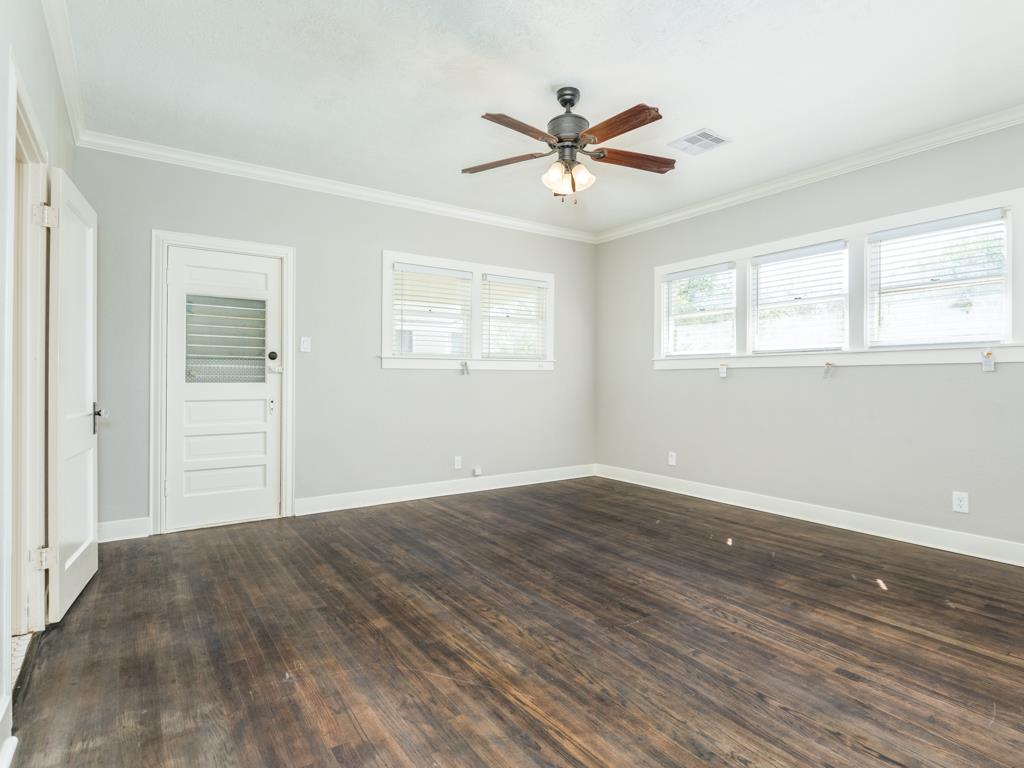 4528 Avenue R 1/2 Galveston, TX 77551 - Photo 18 of 22 a view of a big room with wooden floor and windows in a room