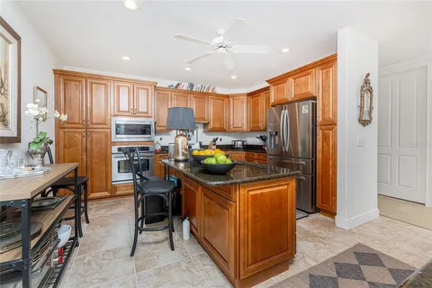 a kitchen with stainless steel appliances granite countertop a refrigerator and a stove top oven